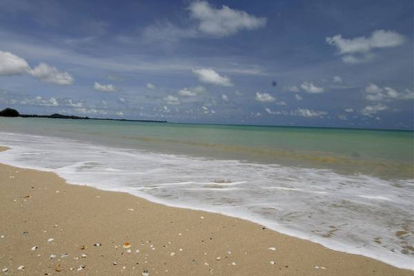 Foto einer Strandlinie mit sanften Wellen und blauem Himmel, bedeckt mit Wolken, vor dem Bangsak Village Hotel