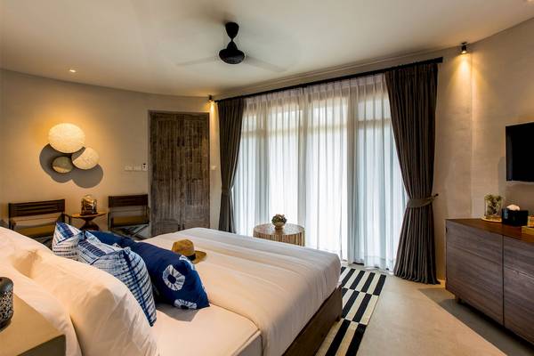 Schlafzimmer im Bangsak Village Hotel mit Bett, Fenstern und Möbeln.