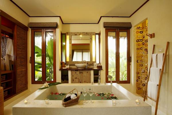 Badezimmer im Bangsak Village Hotel mit Badewanne, Aussicht auf Garten und Candles