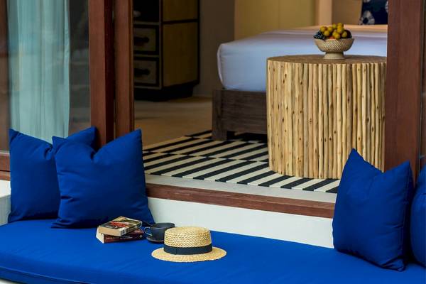 Sitzecke im Bangsak Village Hotel mit blauen Kissen und einem Holztisch.