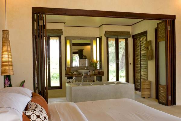 Schlafzimmer im Bangsak Village Hotel mit großem Bett und Badewanne.