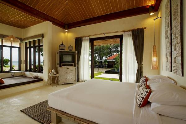 Schlafzimmer im Bangsak Village Hotel mit Blick auf das Meer, mit einem Bett, Fernseher und Fenstern.