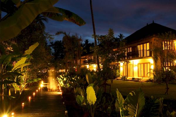 Bangsak Village Hotel bei Nacht mit Beleuchtung und Pflanzen im Vordergrund.