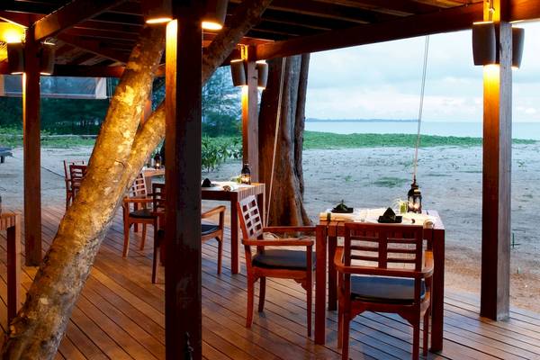 Außenbereich des Bangsak Village Restaurants mit Tischen und Stühlen an der Küste.