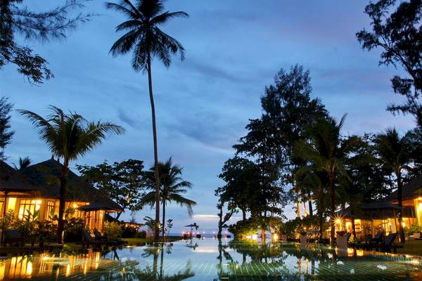 Abendlicher Blick auf das Bangsak Village Hotel mit Swimmingpool und tropischen Bäumen.