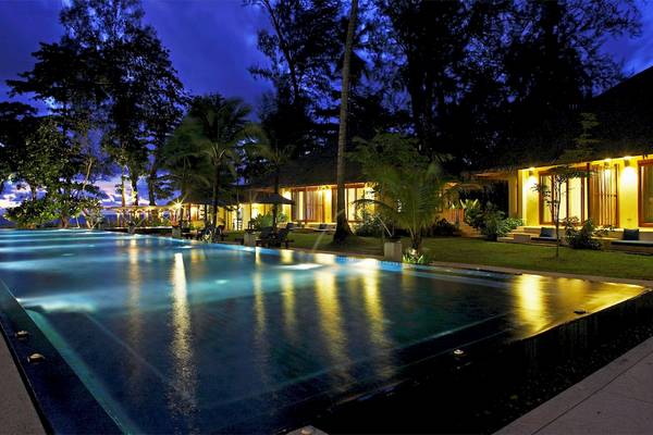 Nachtansicht des Bangsak Village Hotels mit beleuchtetem Pool und umliegenden Gebäuden