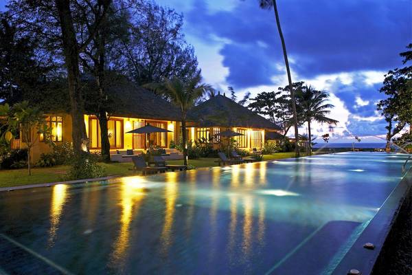 Bangsak Village Hotel Pool bei Nacht mit illuminiertem Gebäude und Loungestühlen
