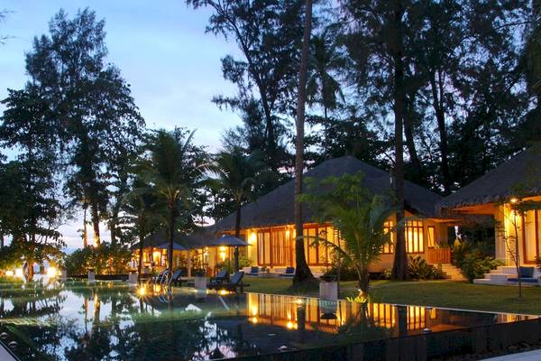 Abendliche Ansicht des Bangsak Village Hotels mit Swimmingpool und illuminierten Bungalows.