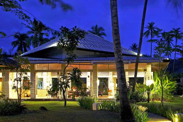 Außenansicht des Bangsak Village Hotels bei Nacht mit beleuchteten Fenstern und Veranda.