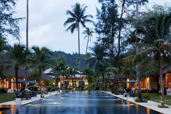 Außenbereich des Bangsak Village Resorts mit Swimmingpool, Palmen und Gebäuden.
