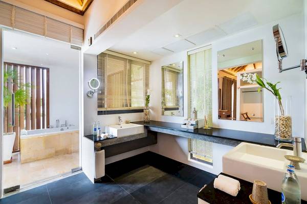 Ein elegantes Badezimmer mit Marmorarbeitsplatte, zwei Waschbecken, Badewanne und Dusche in den TreeHouse Villas Koh Yao.