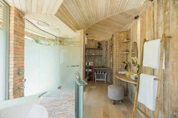 Innenansicht des Badezimmers der TreeHouse Villas Koh Yao mit Holzwänden und einer Dusche.