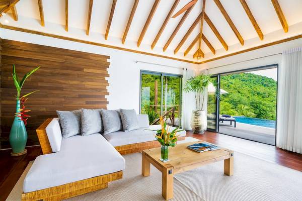 Wohnzimmer mit L-förmigem Sofa, Kaffeetisch und Blick auf den Pool