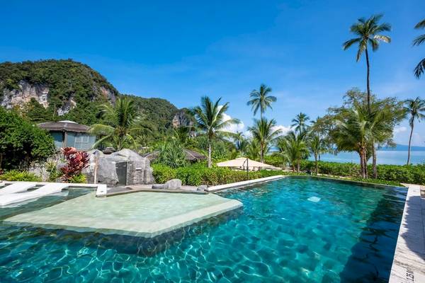 Ein Pool vor den TreeHouse Villas Koh Yao mit Blick auf das Meer und die Berge.