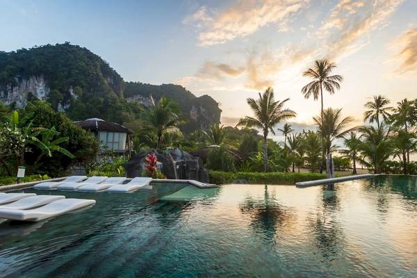Pool am Strand des TreeHouse Villas Koh Yao mit weißen Liegen und tropischen Palmen