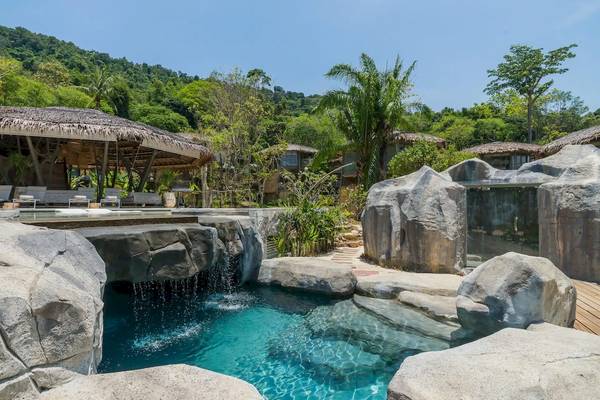 Poolbereich der TreeHouse Villas auf Koh Yao mit Wasserfall und Felsstrukturen