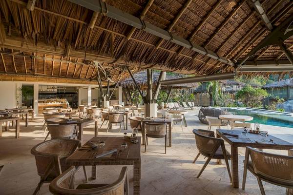Innenansicht des Restaurants der TreeHouse Villas Koh Yao mit Tischen und Stühlen und Blick auf den Pool.