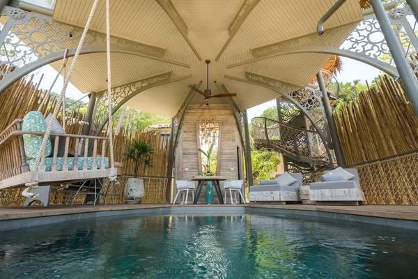 Außenbereich des Treehouse Villas Koh Yao mit Pool, Sitzmöbeln und Hängematte.
