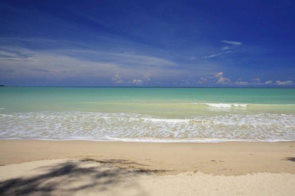 Haadson Resort Strand mit blauem Himmel und sanften Wellen.