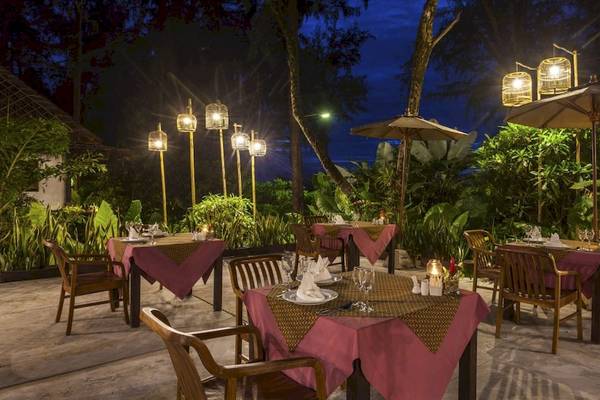 Außenbereich des Haadson Resorts Restaurant bei Nacht mit gedeckten Tischen und tropischer Umgebung.