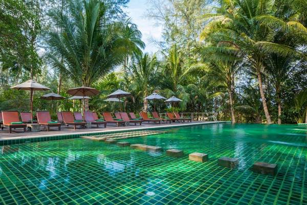 Pool des Haadson Resorts mit Sonnenliegen und Sonnenschirmen unter Bäumen