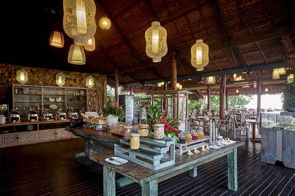 Innenansicht des Speisesaals im Khaolak Paradise Resort mit Buffet, Tischen und hängenden Lampen.