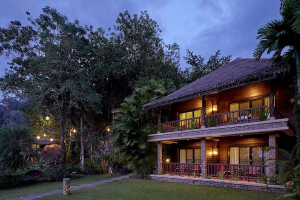 Khaolak Paradise Resort Villa bei Nacht mit beleuchteten Wegen und Balkon mit Möbeln.