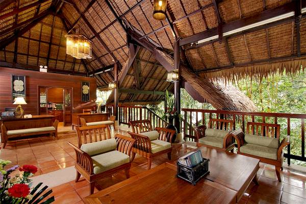 Loungebereich im Khaolak Paradise Resort mit Holzmöbeln, Pflanzen und einer Aussicht auf den Dschungel.