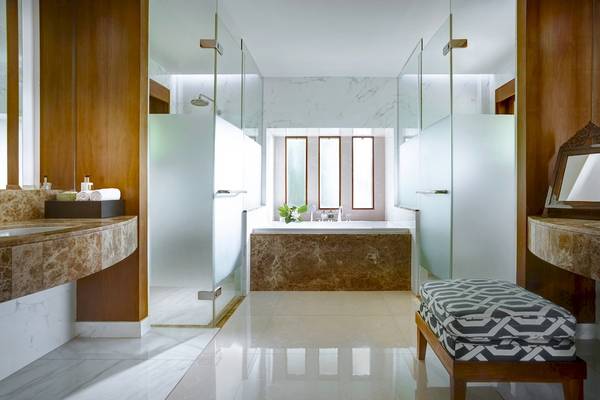 Badezimmer im Santiburi Koh Samui Hotel mit Marmorfliesen, Badewanne und Glasdusche.