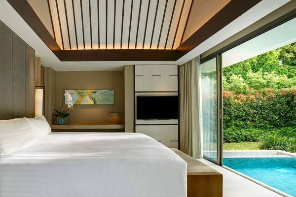 Santiburi Koh Samui Hotelzimmer mit Bett, Fernseher, Tisch und Pool