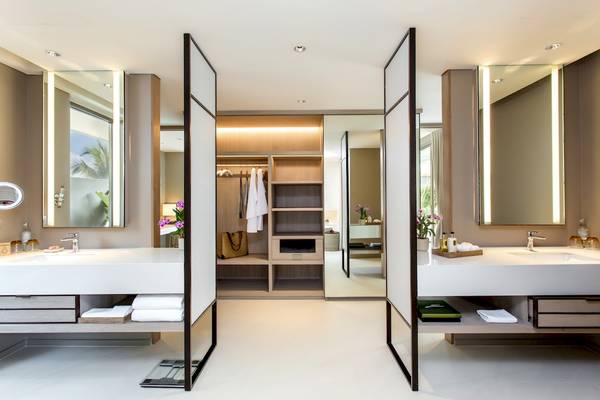 Badezimmer mit Garderobe im Santiburi Koh Samui Hotel, mit Spiegeln und zwei Waschbecken.