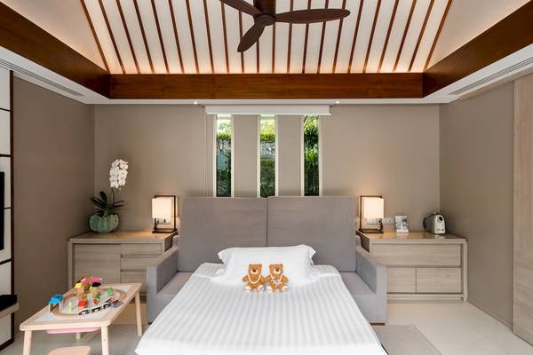 Foto von einem stilvollen Kinderzimmer im Santiburi Koh Samui Hotel, mit einem Bett, Spielzeug und Fenstern.