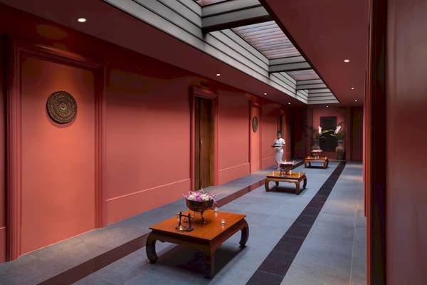 Innenbereich des Santiburi Koh Samui Hotels mit rotem Korridor und Blumentischen