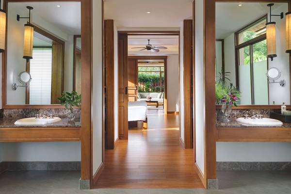 Badezimmer im Santiburi Koh Samui Hotel mit offenem Flur und Schlafzimmer im Hintergrund.