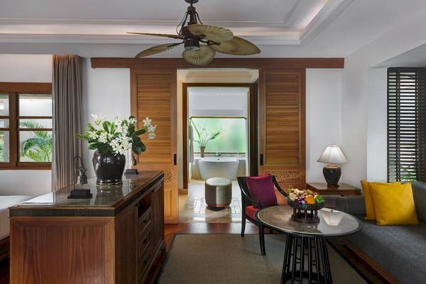 Hotelzimmer im Santiburi Koh Samui mit Badewanne und Sofa.