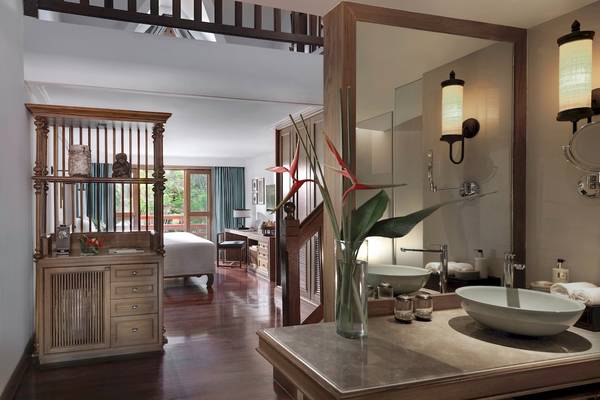 Innenansicht des Badezimmers im Santiburi Koh Samui Hotel mit Doppelwaschbecken und Spiegel.