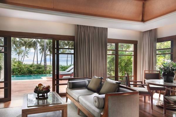 Wohnzimmer im Santiburi Koh Samui mit Blick auf den Pool und die Terrasse.