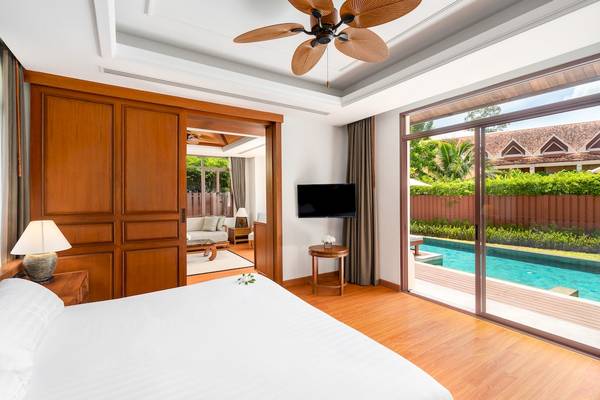 Hotelzimmer im Santiburi Koh Samui mit Blick auf den Pool und die Gartenlandschaft.