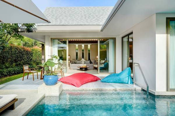 Außenbereich des Santiburi Koh Samui Hotels mit Pool, Loungekissen und Wohnzimmer