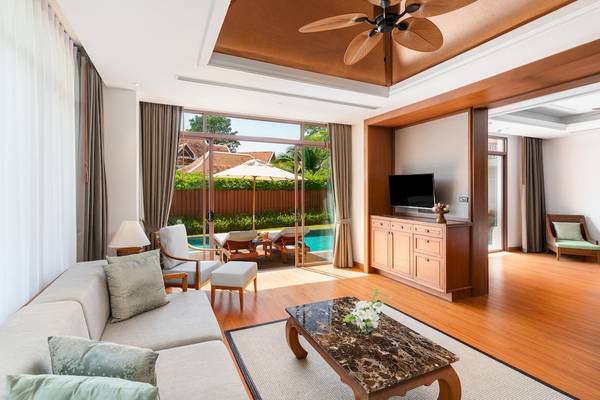 Wohnzimmer im Santiburi Koh Samui mit Blick auf den Pool und Gartenmöbeln