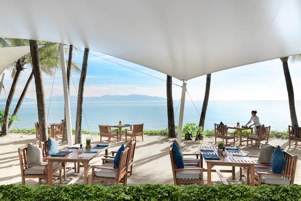 Strandrestaurant des Santiburi Koh Samui mit Blick auf das Meer und Palmen.
