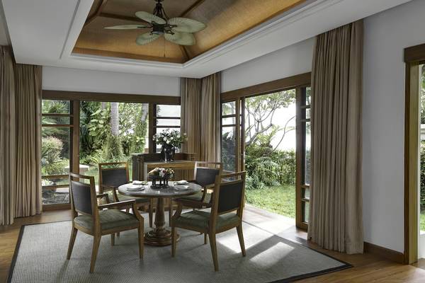 Speisebereich im Santiburi Koh Samui Hotelzimmer mit Tisch, Stühlen und Fenstern.