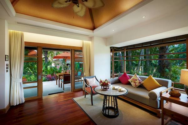 Wohnzimmer des Santiburi Koh Samui Hotels mit Zugang zur Terrasse.