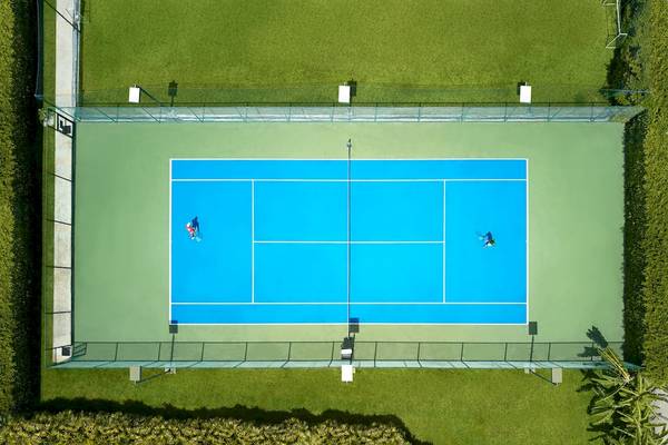 Luftaufnahme eines blauen Tennisplatzes mit zwei Spielern auf Santiburi Koh Samui