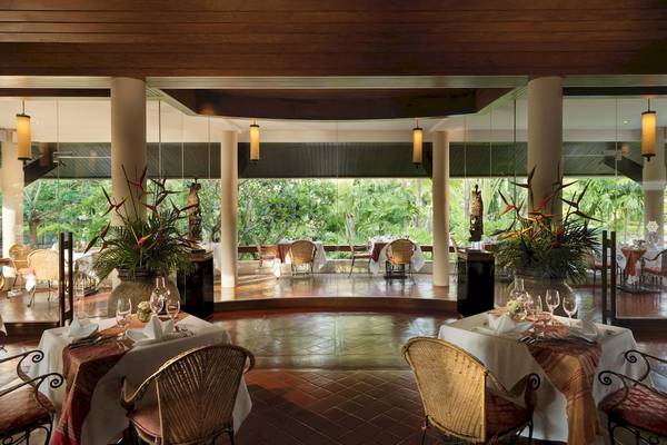 Innenansicht des Restaurants im Santiburi Koh Samui Hotel mit gedämpften Lichtern und Tischdekoration.
