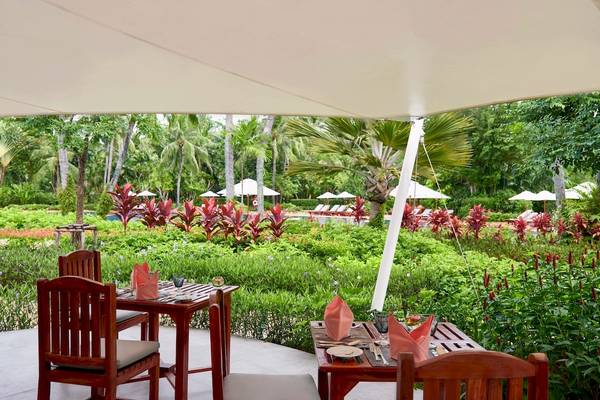 Gartensitzplatz mit zwei Tischen im Santiburi Koh Samui Hotel.