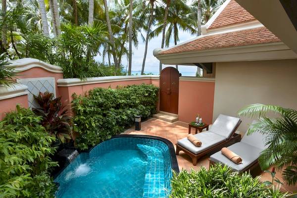 Außenbereich der Suite im Santiburi Koh Samui mit Pool und Sonnenliegen.