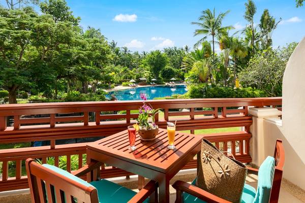 Balkon des Santiburi Koh Samui Hotels mit Blick auf den Pool und tropischen Bäumen.