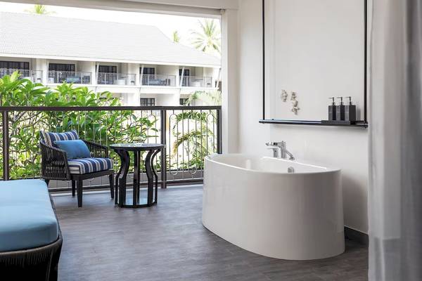 Suite im Meliá Koh Samui mit Balkon und Badewanne, Blick auf Gebäude und Bäume