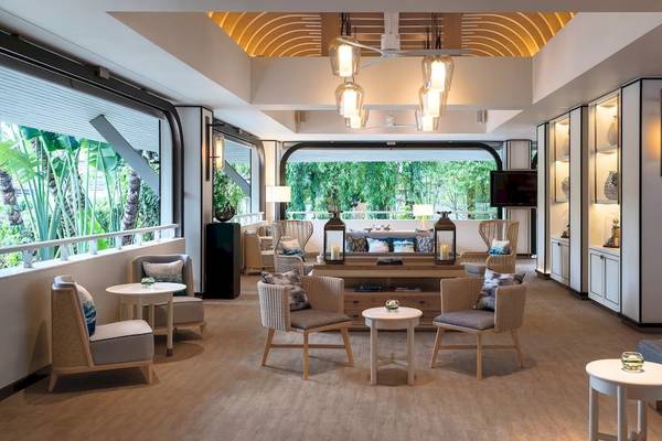 Lobbybereich des Meliá Koh Samui Hotels mit Möbeln und Fenstern.